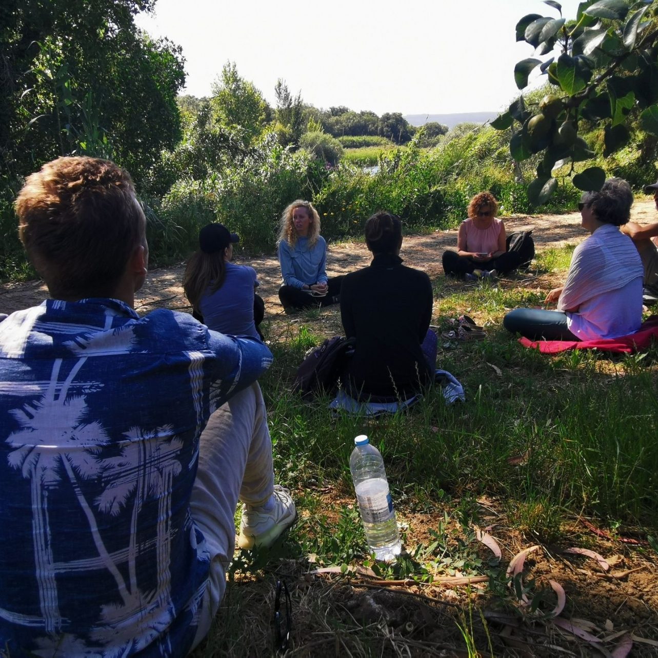 Kirsten sitting on the ground in a field guiding a personal enquiry class