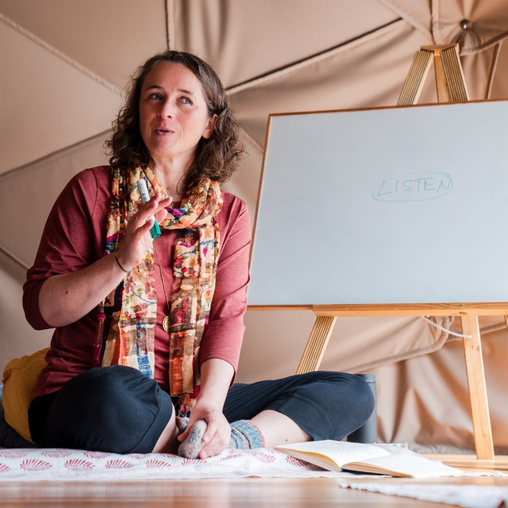 Katrin sitting next to a whiteboard talking about listening